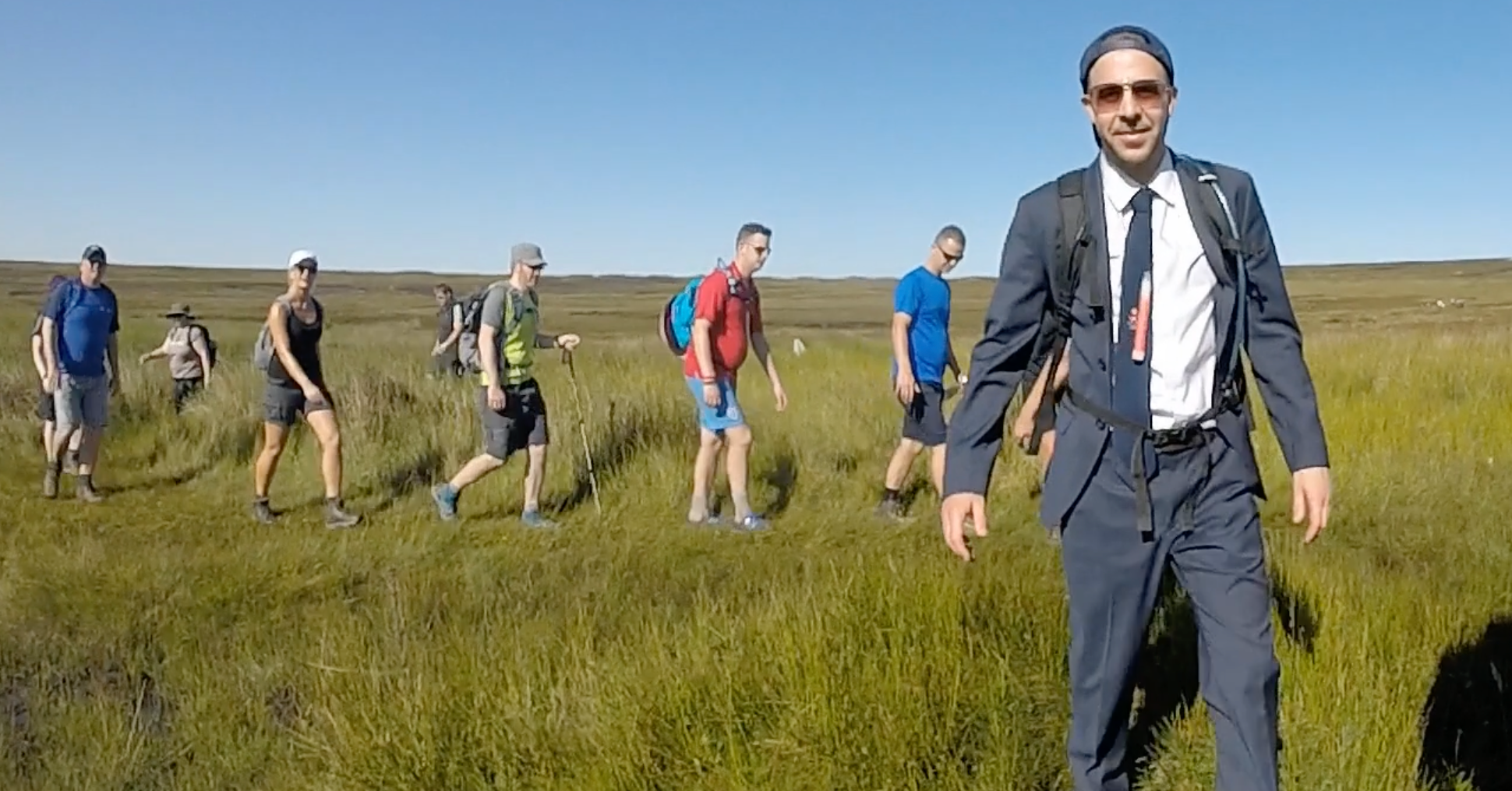 group of people walking through a field 