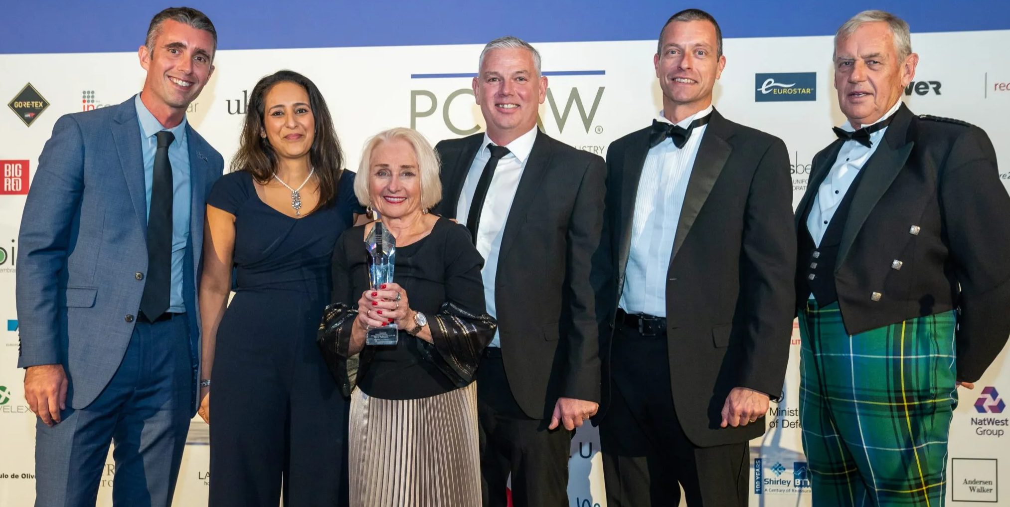 A group of people posing for a photo holding an award