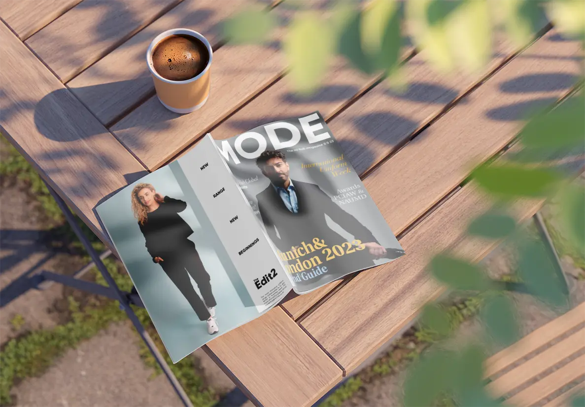 A magazine on a table next to a coffee. 