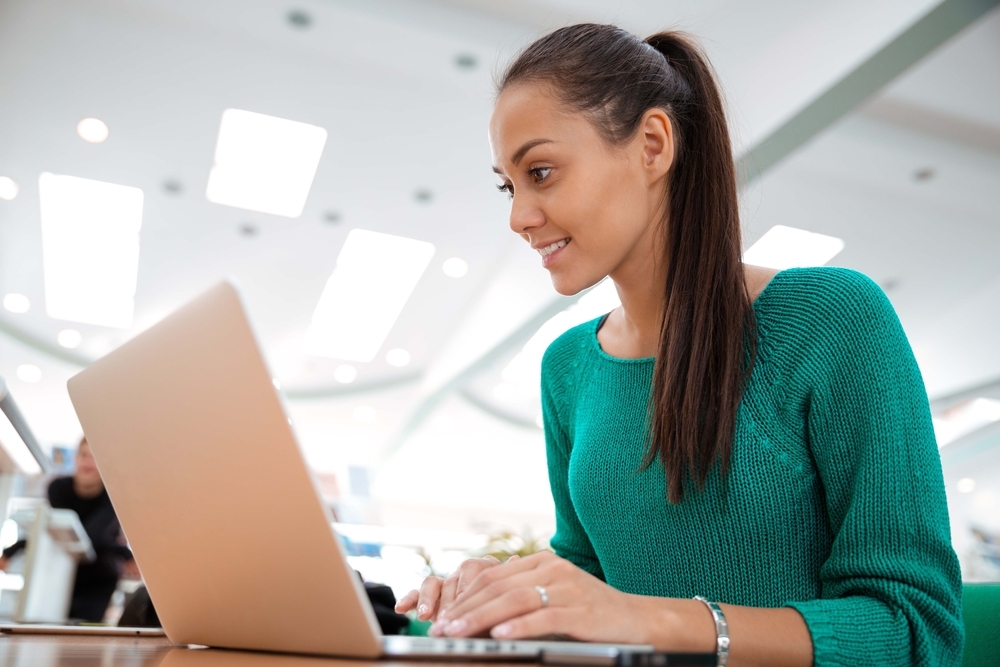 A woman sat at a desk working on a laptop