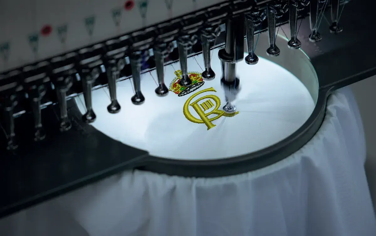 A close-up of a white shirt as a logo is embroidered.