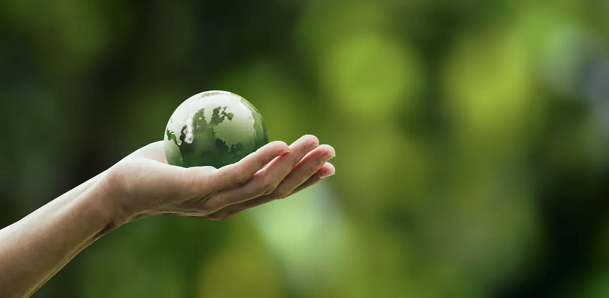 An outreached arm holding a model of the globe. 